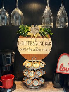 a coffee and wine bar with cups on the counter next to some hanging wine glasses