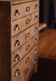 a wooden drawer with metal knobs on it