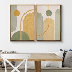 two paintings hang on the wall above a table in a room with couches and chairs