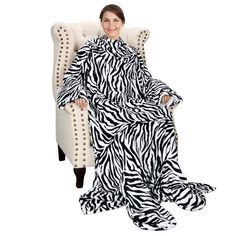 a woman sitting in a chair wearing a zebra print dress