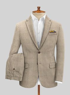 A suit elevates an office essential to the rarified realm of an everyday staple. Crafted from pure wool, our suit features a houndstooth pattern ideal for cold temperatures and brings some charm and fun loving spirit when you head on a cold, drizzly day. It will be a great addition and you will be glad to make it a part of your journey. A venturesome piece that will give you the best bold look and many styling options without exerting much effort.  Look Includes   Houndstooth Beige Tweed Fabric  Two Button Jacket Style  Notch Lapel  Horn Brown Buttons  Single Vent  Three Cuff Buttons  Two Welted Back Pockets on Trousers    Click 'Customize Now' to modify the look if needed.   Lining: Viscose; Dry Clean. Classic Houndstooth Suits For Winter, Tweed Jacket With Houndstooth Pattern For Business Casual, Classic Winter Houndstooth Suit, Tailored Houndstooth Tweed Jacket For Business, Semi-formal Houndstooth Tweed Jacket, Semi-formal Tweed Jacket With Houndstooth Pattern, Tweed Blazer With Houndstooth Pattern, Formal Houndstooth Tweed Jacket With Notch Lapel, Tailored Houndstooth Suit For Fall