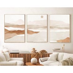 three paintings hanging on the wall above a couch in a living room with white furniture