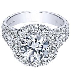 a white gold engagement ring with an intricate halo setting and round diamonds on the band