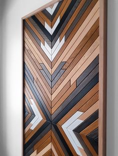 a wooden panel with white and black designs on it's sides in a room