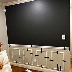 an empty room with black walls and white trim on the wall, taped together by blue tape