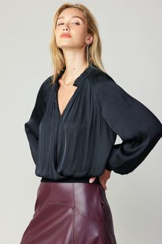 Cut for a relaxed silhouette, this airy surplice top flatters with its V-shaped neckline and ribbed trim that draws in the shape. The style is accented by ruffle detailing and a touch of smocking at the shoulders, adding an extra dose of feminine flourish. •Surplice style •Hidden snap fastening at neckline •Smocked shoulders •Ruffle trim •Long sleeves •Banded rib trim •Relaxed Fit DIMENSIONS •Standard: 23" Length Item number 2230092100% Polyester Chic Solid Surplice Neckline Tops, Chic Surplice Neckline Tops, Solid V-neck Blouse For Layering, Chic Solid Color Split Neck Tops, Chic V-neck Blouse For Layering, Versatile V-neck Blouse For Night Out, Chic Surplice Neckline Top For Layering, Chic Tops With Surplice Neckline For Workwear, Chic Surplice Neckline Top For Workwear