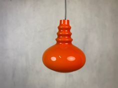 an orange light bulb hanging from a ceiling