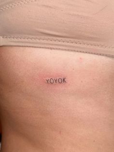 a woman's stomach with the word yook tattooed on her lower side belly