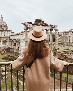 a woman standing on top of a balcony next to an old roman building with the words gi