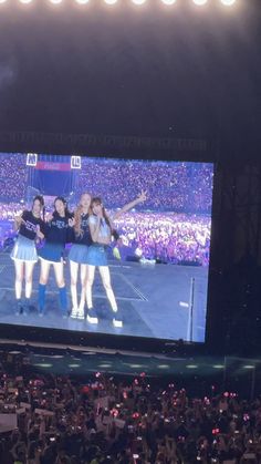 a group of women standing on top of a tennis court in front of a crowd