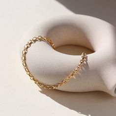 Picture a sleek and elegant gold bracelet, designed with minimalism in mind. It features a delicate chain crafted from shimmering 14k gold fill, offering a subtle yet luxurious glow. This piece embodies sophistication and refinement, perfect for adding a touch of timeless elegance to any ensemble. DETAILS14k gold fill Hypoallergenic, water proof, and nickel free To determine your wrist size, use a tape measure or ribbon around your wrist, then measure against a ruler. Elegant Recycled Gold Bracelets, Tarnish Resistant, Gold Minimalist Bracelet For Formal Occasions, Elegant Recycled Gold Tarnish-resistant Bracelets, Elegant Tarnish-resistant Recycled Gold Bracelets, Minimalist Tarnish Resistant Recycled Gold Bracelet, Formal Gold Minimalist Bracelet, Formal Minimalist Gold Bracelet, Minimalist Oval Link Bracelet For Formal Occasions, Timeless Gold Plated Bracelet For Everyday Wear