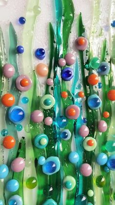 an art glass sculpture with many different colored balls and flowers on it's sides