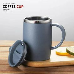 the coffee cup has a lid and is next to sliced lemons on a cutting board