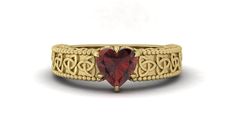 a gold ring with a heart shaped red stone in the center, surrounded by filigrees