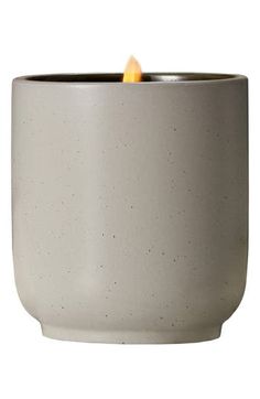 a candle is lit in a white ceramic bowl