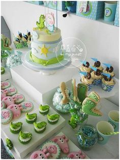 a table topped with lots of cakes and cupcakes