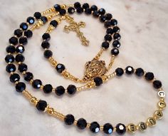 Stunning black and gold Rosary beads, Created with 8mm glass beads, Gold plated medal and cross with stainless steel cord, #Car Bracelet, follow the link (refer to photos). https://www.etsy.com/au/listing/1089430299/hanging-rosary-beadspersonalised-car?click_key=4b61c937486b92293e5330713248d7c273fcfbac%3A1089430299&click_sum=ca4d9f67&ref=shop_home_active_10&pro=1&sts=1 #Measures 53cm from the bottom tip of the cross to the top half of the rosary  18cm drop 72cm necklace (depending on how many na Catholic Necklace, Gold Rosary, Rosary Catholic, Rosary Beads, Prayer Beads, Family Name, Shop Home, Rosary, Black And Gold