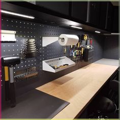 there is a workbench with many tools on the wall and in the cabinet