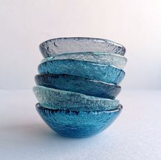 four blue glass bowls stacked on top of each other