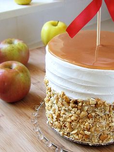 there is a cake on the table with apples and an apple in the back ground