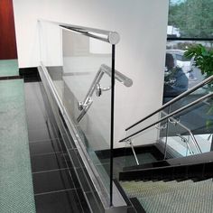 an escalator in a building with glass railings on the bottom and handrail