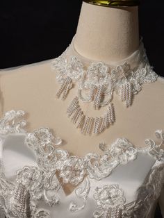 a white wedding dress with pearls and lace