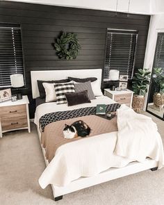 a cat laying on top of a bed in a room with black and white decor