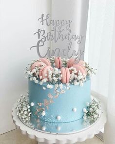 a blue birthday cake with pink and white frosting