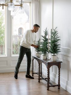 a man standing next to a table with a christmas tree on it