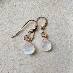 Our simple dainty moonstone drop earrings are a classic pair and the perfect lightweight everyday earring. The genuine moonstone gemstones are striking and make a minimalist statement. Because of their simple style, they are the perfect pair to complement a necklace. They would make a beautiful personalized gift as we offer a choice of every month's birthstone as well as other popular gemstones in the drop-down menu. Also available in gold filled, sterling silver, rose gold filled and 14k gold. The model is wearing the moonstone June birthstone earrings in 14k gold filled. CRAFTSMANSHIP  Jewelry is handmade by us in our NYC studio. We focus on craftsmanship and quality using only the highest quality materials and handpicked genuine gemstones.  PACKAGING We take pride in creating beautifull Adjustable Teardrop Moonstone Earrings, Minimalist Nickel Free Moonstone Earrings, Round Moonstone Earrings, Minimalist Nickel-free Moonstone Earrings, White Moonstone Earrings For Daily Wear, Everyday Round Moonstone Earrings, Delicate White Moonstone Earrings, Moonstone Moon Charm Drop Earrings, Dainty Nickel-free Moonstone Earrings