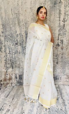 Simple white Kota Check inspired Banarasi saree with good zari dots embroidered all over the body. Zari palli simple and unique. Its just a very simple yet beautiful saree... Color White Saree is light , drapes easily , has a beautiful shine and overall a very good choice. The saree is ready to wear with falls, pico and beautiful handwoven tassels , and unstitched blouse fabric is included. Note: Colors that show up on your screen may vary slightly from the actual product due to variations in settings. Also, the actual product may appear to be different hues depending on the ambience lighting. Note: There may be very slight inconsistencies such as in the weave/motifs work, there being characteristics are not considered defects. Saree does not come with the jewelry shown in pictures. Ambience Lighting, White Saree, Embroidered Saree, Banarasi Saree, Jewelry Show, Simple White, Banarasi Sarees, Beautiful Saree, Blouse Fabric