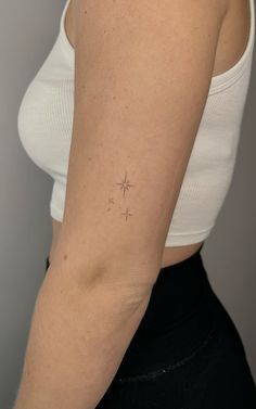 a woman's arm with a small star tattoo on the left side of her arm