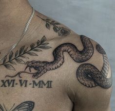 a man with a tattoo on his chest has a snake and leaves around him that says mm - vm