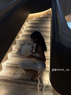 a woman sitting on some stairs looking at a map