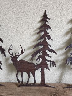 three metal deer and trees on a wooden table