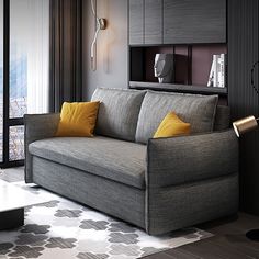 a living room with a gray couch and yellow pillows on the armrests next to a large window