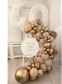 a large balloon arch with gold and pink balloons in the shape of an o on it