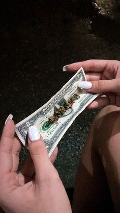 two hands holding one dollar bill with white nails