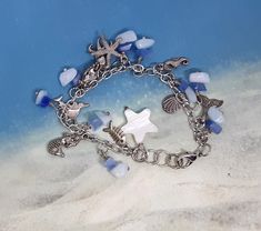 Women charm bracelet, chain, lobster clasp bracelet,  chip beads, white shell star, beach theme, women or girls,  silver and blue, handmade, beach, ocean Made with love by aunt lu Adjustable Ocean-inspired Charm Bracelet With Lobster Clasp, Blue Charm Bracelets For The Beach, Silver Starfish Charm Bracelet For Beach, Silver Charm Bracelet With Starfish For Beach, Silver Charm Bracelet With Lobster Clasp For Beach, Silver Charm Bracelet For The Beach, Silver Beaded Bracelet With Lobster Clasp For Beach, Handmade Silver Charm Bracelet For Beach, Beach Charm Bracelet