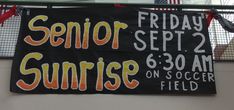 a sign hanging from the side of a building that says senior sunrise on soccer field