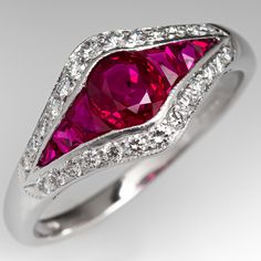 This beautiful contemporary ruby ring is centered with an oval cut ruby, weighing 0.67 carats, in a channel setting. The center is flanked on either side by three (3) channel set, calibre' cut rubies. The outer edge of the ring is bead set with a total of twenty-six (26) round brilliant cut diamonds. The ring measures 9.2mm at the top, rises 3.8mm above the finger, tapering to 1.8mm wide and 1.0mm thick at the base of the shank. Signed with the London, 18K white gold hallmark. The ring is curren Ruby Ring Vintage, Ruby Rings, Ruby Wedding, Channel Setting, Ruby Engagement Ring, Bead Set, Ruby Jewelry, Wide Band Rings, July Birthstone