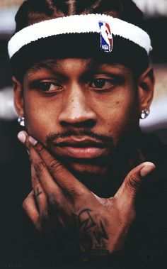 a man with his hands on his chest wearing a white headband and holding his hand in front of his face