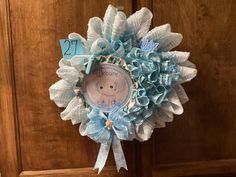 a blue and white clock hanging from the side of a wooden door