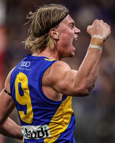 a male afl player celebrating his team's win