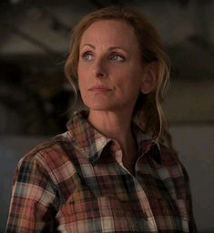 a woman in plaid shirt looking off into the distance