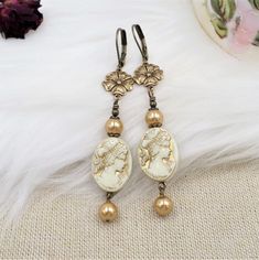 This listing features my handmade earrings created by me with unique elements!  The focal beads are ACRYLIC vintage style beads, done in cream with metallic gold accents that showcase a beautiful Victorian maiden on both sides.  These cameo beads are so nicely done!  I have added brass flower connectors and bright gold crystal cored faux pearls. The earrings are light due to the elements and measure 3 inches long including the brass lever back wires.  Thank you for visiting - please click here t Aesthetic Royalcore, Academia Coquette, Victorian Maiden, Gold Pearl Jewelry, Romantic Academia, Art Nouveau Earring, Peacock Necklace, Asian Jewelry, Cameo Earrings