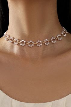 Classic Flower Pearl Choker Necklace, this exquisite necklace features lustrous pearls interspersed with delicate flower design, creating a harmonious blend of classic beauty and modern charm. The pearl sits gracefully around the neck, making it a perfect accessory for any occasion. Matching Bracelet SKU# 40B114 Product Details:length: 16"charm: .5"ext: 3" Ball Chain Extclasp: Lobster Clawmetal finish: Gold Platedproduct: Lead & Nickel Compliantanti-tarnish: Double E-coating Pearl necklace | Flo Trendy Pearl Necklace, Modern Pearl Necklace Design, Modern Pearl Necklace, Classic Flower, Pearl Necklace Designs, Necklace Flower, Pearl Jewelry Necklace, Gold Charm Necklace, Pearl Choker Necklace