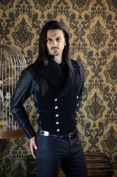 "An elegant double breasted vest for formal occasions. A fitted vest made in rich black velvet fabric with a stand up top collar and wide sweeping lapels. Fastens on the inside with a sturdy button and buttons on the outside with five antiqued metal buttons. The vest back and inside lining is made from rich black satin. Comes in sizes small-XXXL. Wonderful! Measurements: Small: Chest 39\" Stomach 36\" Waist 34\" Medium: Chest 42\" Stomach 38\" Waist 36\" Large: Chest 44\" Stomach 42\" Waist 40\" Steampunk Formal Sleeveless Vest, Formal Steampunk Sleeveless Vest, Gothic Fitted Vest With Buttons, Formal Sleeveless Steampunk Vest, Fitted Gothic Vest For Winter, Fitted Gothic Velvet Outerwear, Gothic Fitted Velvet Outerwear, Gothic Black Vest For Costume Party, Gothic Fitted Sleeveless Outerwear