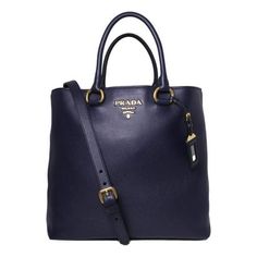 This Prada navy shopping tote is absolutely adorable and is perfect for everyday wear. There is plenty of storage space for your personal belongings. This beautiful navy blue color goes great with most everyday looks and looks stunning with the Prada Paris logo. Includes authenticity cards and Prada dust bag. Model: 1BG865 Navy Blue Leather Gold-tone Hardware Open Closure Detachable/Adjustable Shoulder Strap Strap Drop: 20" inches Double-handle drop: 7" inches Measurements: 14" x 6" x 12" (LWH) Navy Bag With Top Handle, Luxury Navy Shoulder Bag With Gold-tone Hardware, Navy Bags With Detachable Double Handle, Navy Bag With Detachable Double Handle, Luxury Navy Bags With Gold-tone Hardware, Navy Leather Bag With Handles, Navy Tote Bag With Top Carry Handle, Everyday Navy Bag With Handles, Navy Double Handle Bag With Top Carry