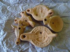 four carved ceramic animals sitting on top of a piece of white wax paper with holes in the middle